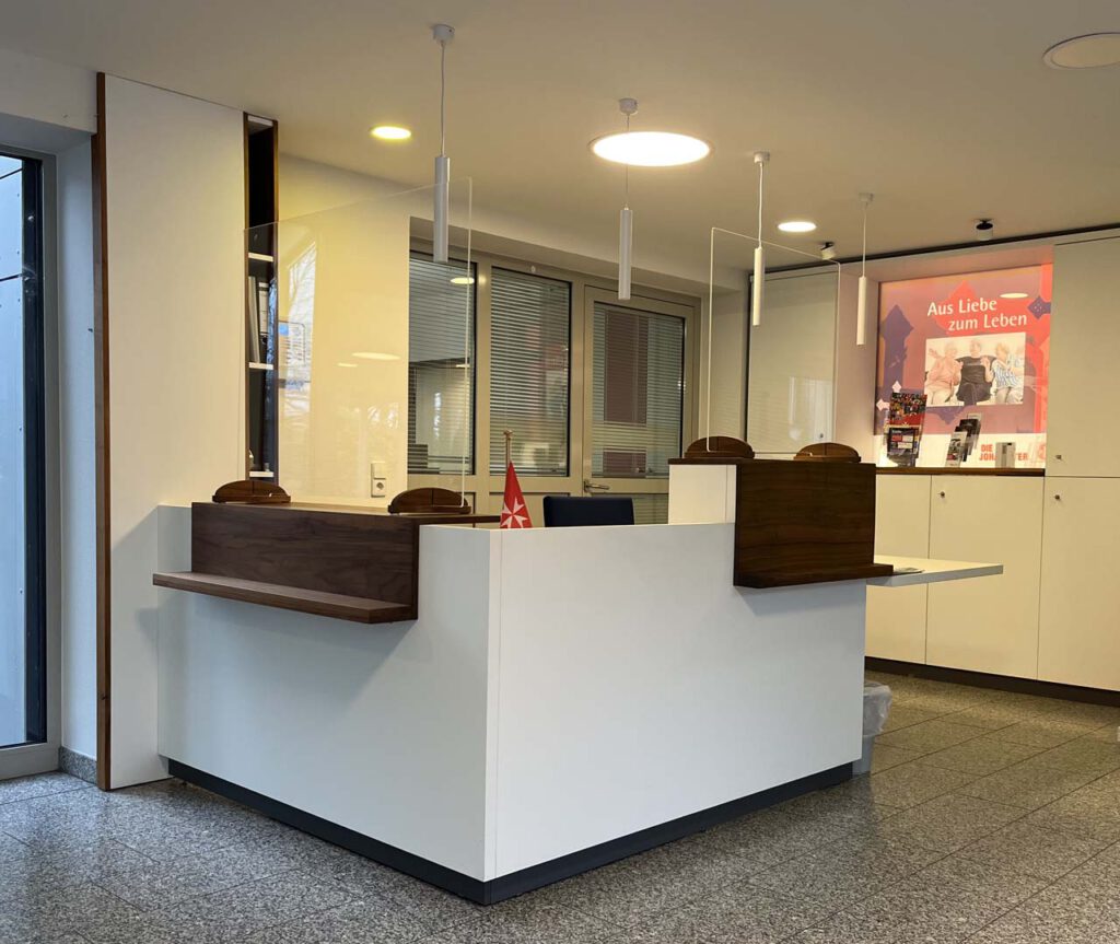 Maßgefertigter Empfangsbereich für ein Seniorenheim in Celle mit modernem Empfangstresen und warmen Holzdetails.