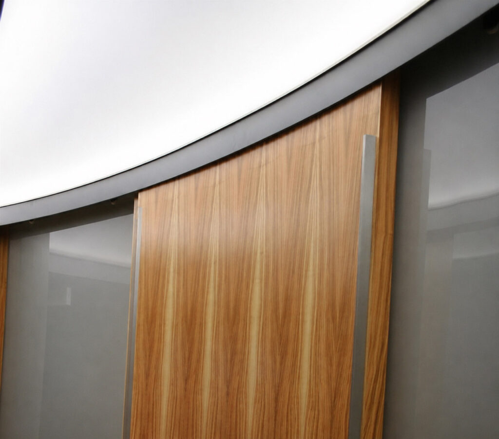 Highlight im Ankleidezimmer gebogene Türfronten aus Holz und Glas mit einer speziellen Laufschiene Handwerkskunst in Perfektion