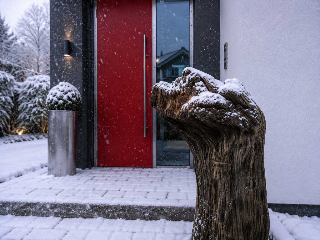 Holzskulptur aus Mooreiche mit Schnee im Winter