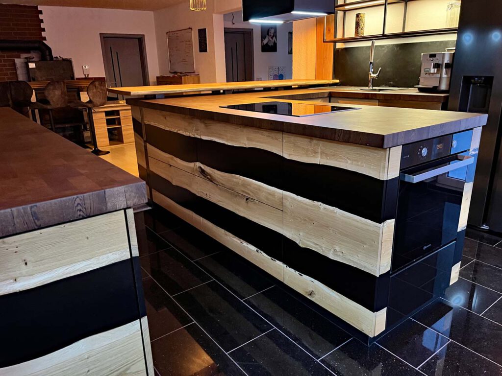 Massivhiolzküche mit schwarzem Epoxid in einem umgebauten Resthof