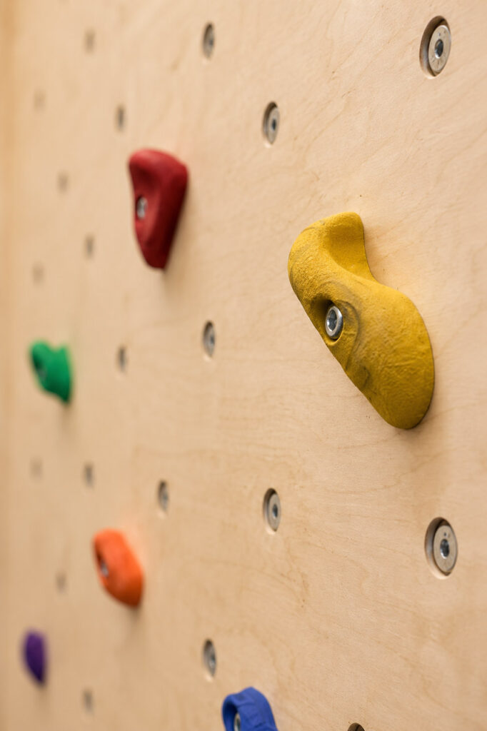Nahaufnahme bunte Klettergriffe für Kinder an einer Boulderwand