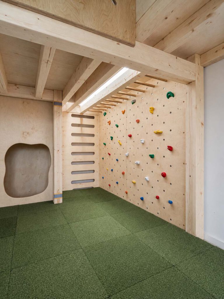 Kletterbereich mit Boulderwand, Hangelstangen und Sprossenwand für Kinder in einer Kita